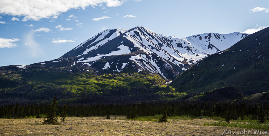 Snow covered mountains in early summer line the primitive road that is delivering us to the Alsek River